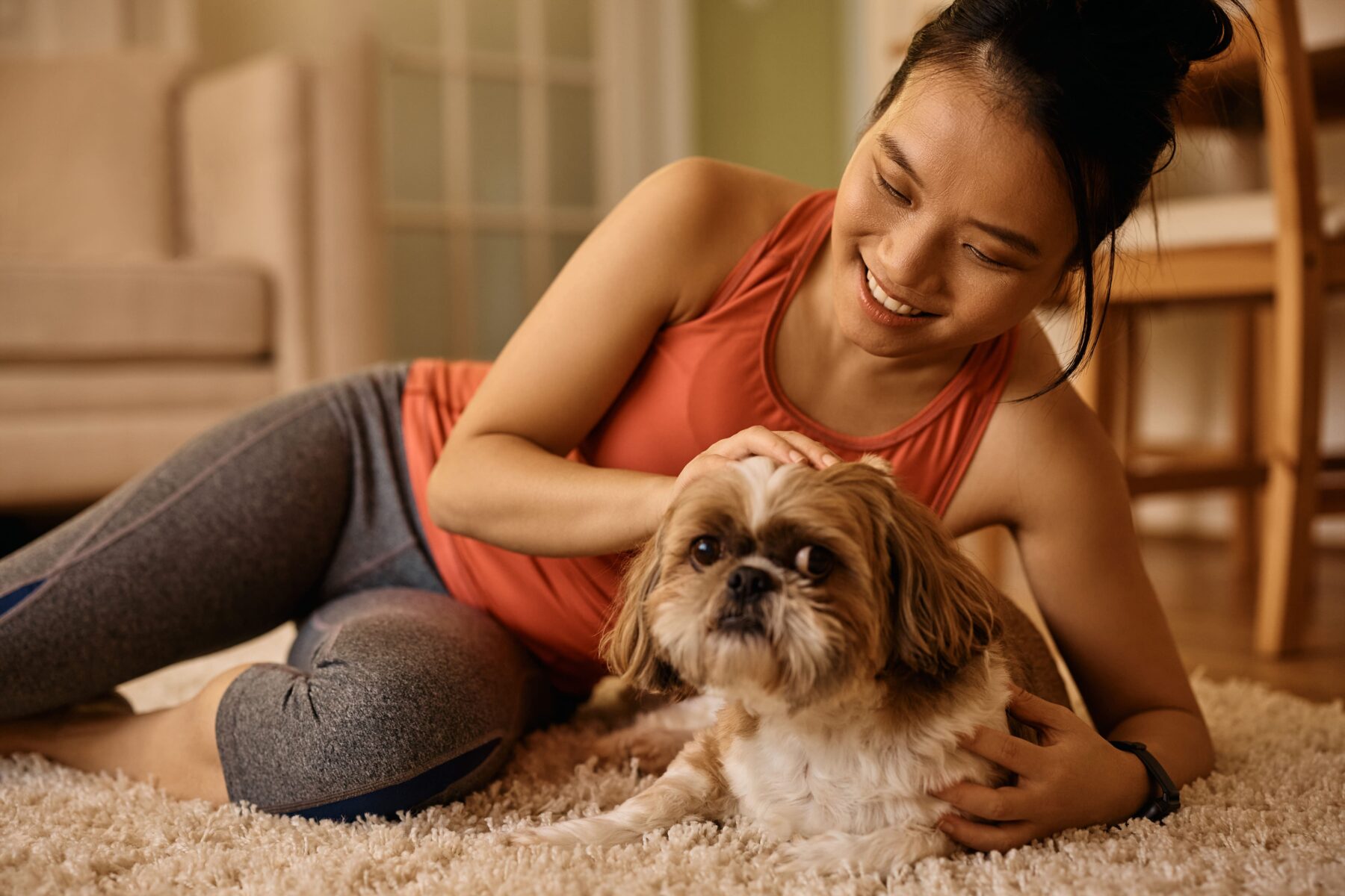 Mulher deitada no chão com seu cachorro.