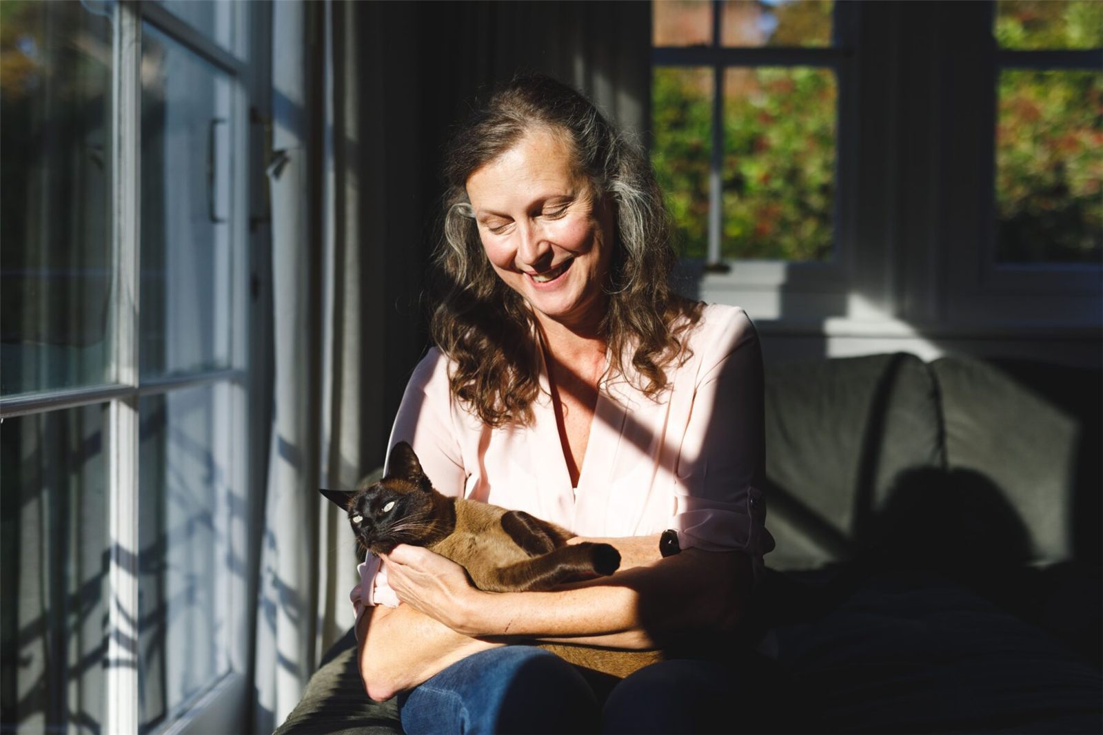 Mulher segurando um gato no colo.